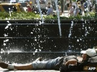Person lies out in the park in Manhattan in the sun