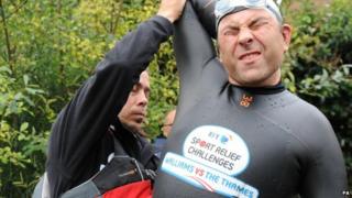 David Walliams stretches before getting back in the River Thames to continue his charity swim in aid of Sport Relief