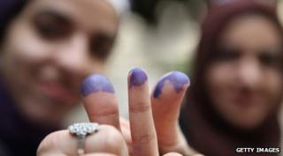 Women have their fingers marked with ink to show that they have voted