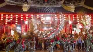 Soldiers perform a dragon-dance in front of a temple in Indonesia.