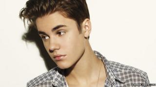 Justin Bieber appeared with quiffed hair, wearing a grey checkered shirt.