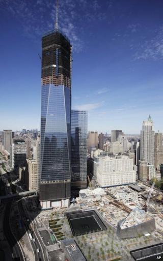 One World Trade Center dwarfs its neighbouring buildings. It is a tall, monolithic stucture clad with glass.