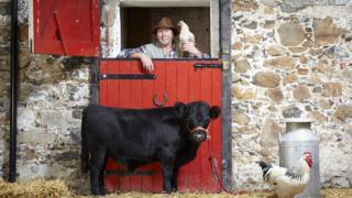 Farmer poses with the smallest bull in the world.