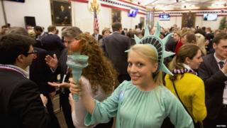 A woman dressed as the Statue of Liberty poses for photographs during an election party at the US Embassy in London