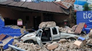 Car in ruins of collapsed house