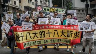 Pro-democracy lawmaker Lee Cheuk-yan and other demonstrators who hold placards and a banner as they march towards the Chinese liaison office during a protest against Beijing"s central government in Hong Kong.