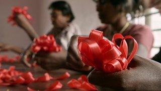ВИЧ-позитивные женщины плетут красные ленточки — универсальный символ информированности и поддержки людей, живущих с ВИЧ
