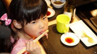Girl eats bluefin tuna sushi