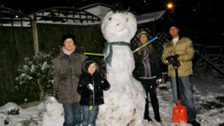 A family with an enormous snowman.