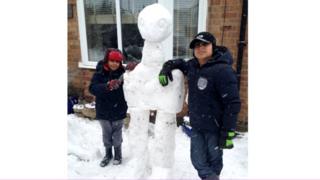 Two boys with their snow alien.