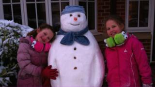 Two girls with a snowman.