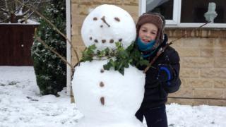 A boy with his snowman.