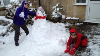 Two children with their snowman.