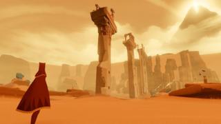 A robed figure stares across a vast desert.