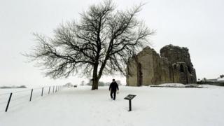 A man walks through the snow at Bowes Castle in County Durham.