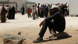Syrian refugees wait to receive aid and rations