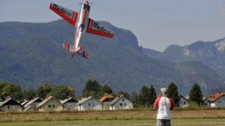 A man flies his model plane during an airshow for radio-controlled airplanes at Lesce airport, Slovenia