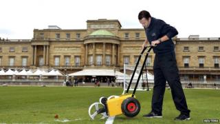 Karl Standley, a groundsman at Wembley Stadium, marks out the the lines of a soccer pitch in the gardens of Buckingham Palace