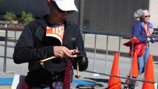 David Babcock knitting just before he finished running the marathon