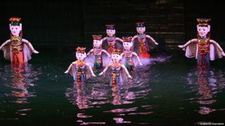 Wooden puppets in waist deep water
