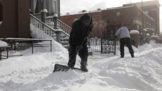 Workers in Detroit shovelling snow
