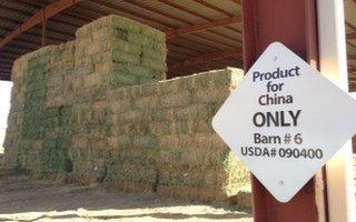Piles of hay behind 'Product for China only' sign