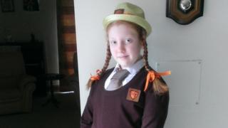 Ellen in school uniform with hat and pigtails