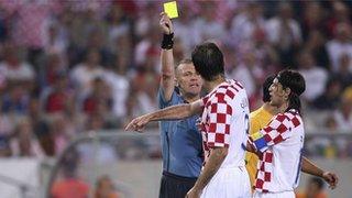 Graham Poll gives Croatia's Josip Simunic a yellow card