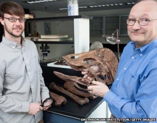 Scientists holding a reconstructed Anzu Wyliei skull