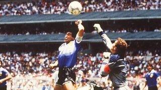 Argentina's Maradona uses his hand to beat England's Peter Shilton to the ball