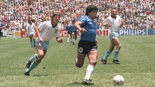 Diego Maradona powers through the England defence to score for Argentina