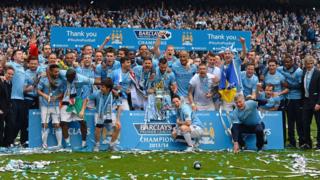 Manchester City players celebrate with trophy