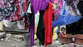 A Filipino child plays outside their home while waiting for pre-emptive evacuation at a slum area in Tondo, Manila, Philippines
