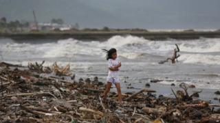girl walks along the shore as strong waves from Typhoon Hagupit hit Atimonan, Quezon province, eastern Philippines on Saturday, Dec.