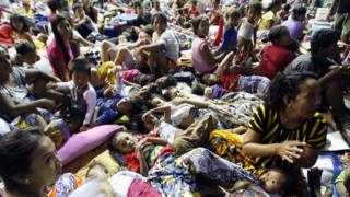 Filipino residents take shelter inside a gymnasium turned into a temporary evacuation center in Mambaling village, Cebu province, central Philippines,