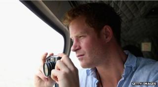 Prince Harry in a car holding a camera