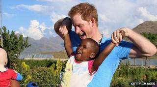 Prince Harry playing with a child