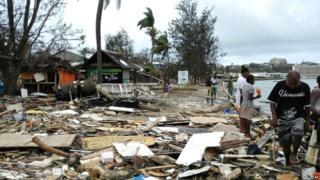 Locals walk past debris in Port Vila, Vanuatu, after Cyclone Pam