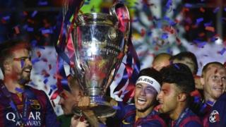 Barcelona's Neymar da Silva Santos Junior holds the trophy as Barcelona's players celebrate the win against Juventus in the UEFA Champions League Final