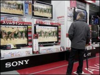 A customer checks Japanese electronics giant Sony's Bravia brand LCD TVs at an electronics shop in Tokyo