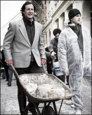 L'Aquila residents protest with wheelbarrows to show their willingness to clear the town of rubble