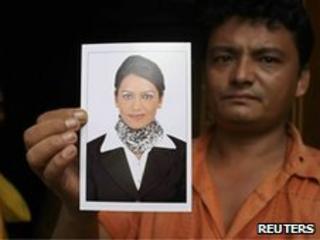 A relative holds a photograph of Sujata Survase, a member of the cabin crew