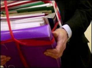 Man holding documents held in red tape