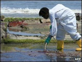 A BP clean-up crew worker cleans oil from a beach in Louisiana, 24 May