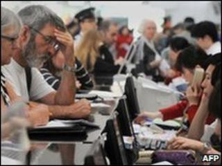 Passengers speak with Hong Kong-based carrier Cathay Pacific employees at an enquiry counter at Hong Kong's International Airport on April 18, 2010.