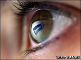 An eyeball reflecting the Facebook logo