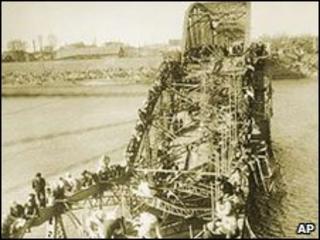 Civilians crawl over a shattered bridge in Pyongyan to escape the advance of Chinese troops