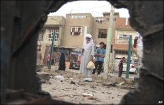 Iraqis inspect a bomb blast site