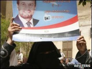 A supporter of the Muslim Brotherhood holds a candidates placard (1 June 2010)