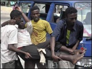 Relatives and staff help carry a wounded man after following a mortar blast during clashes between AU-backed Somali government forces and Islamist insurgents, Mogadishu, 3 June 2010